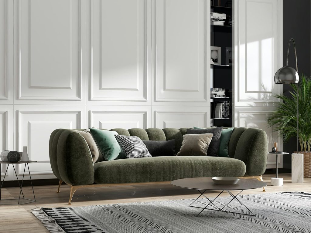 Zielona sofa z jasnym geometrycznym dywanem w nowoczesnym salonie.